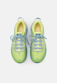 Baskets de sport vert lime avec des accents bleus, tige en mesh, semelle en caoutchouc épaisse et lacets réfléchissants. Comprend une zone de renforcement au niveau des orteils.