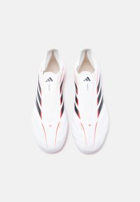 Ζευγάρι λευκών ποδοσφαιρικών παπουτσιών Adidas Copa με μαύρες ρίγες και κόκκινες λεπτομέρειες, από πάνω σε λευκό φόντο.