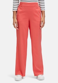 Coral wide-leg pants with an elastic waistband, made of smooth fabric, worn with a striped long-sleeve top and white sneakers.