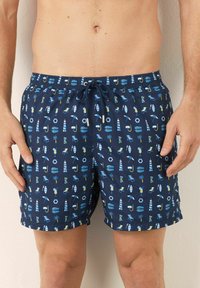 Marinefarbene Schwimmshorts mit einem gemusterten Design, das Sonnen-, Strand- und nautische Symbole zeigt. Das Material ist leicht, mit einem elastischen Bund und Kordelzug.