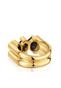 Anillo en tono dorado con un diseño liso y redondeado. Presenta dos piedras preciosas negras circulares, que aportan contraste a la superficie brillante.
