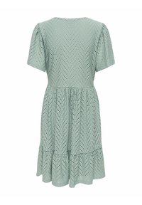 Robe vert clair à manches courtes avec motif œillet chevron, taille froncée et ourlet volanté, vue de dos.