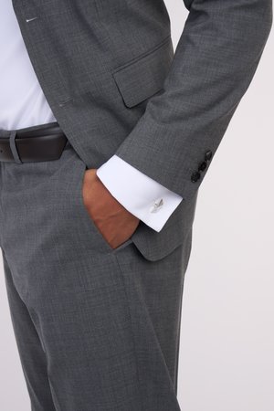 Grau strukturierte Sakko mit texturiertem Finish, weißem Hemd und silbernen Manschettenknöpfen. Verfügt über eine Tasche und Knopfakzente an den Ärmeln.