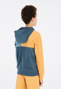 Felpa con cappuccio in pile con un design a blocchi di colore blu e giallo, dotata di cappuccio e texture morbida. Vestibilità semplice e casual con orlo arrotondato.
