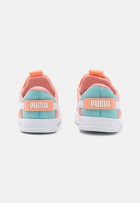 Des chaussures de sport rose et turquoise avec des semelles blanches, présentant un col rembourré, une tige en textile et une languette à l'arrière avec le marquage "PUMA".
