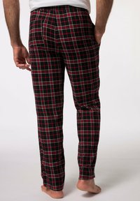 Pantalones de pijama de cuadros en negro, rojo y blanco, con bolsillos laterales y cinturilla elástica, mostrados desde atrás. Material de algodón.