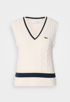 Sweter sem mangas, creme, com ponto de cable e decote em V, com acabamentos em azul-marinho e um logótipo bordado verde no peito. Apresenta detalhes canelados.