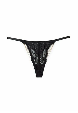 String noir en dentelle avec des motifs floraux, des bretelles réglables et une texture douce. Agrémenté de détails en chaîne dorée pour un contraste supplémentaire.