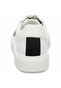 Sneaker bianca con upper in pelle liscia, accentuazione a coste nere sul tallone e suola in gomma textured. Design minimalista.