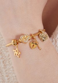 Gouden charm armband met hart-, ster- en sleutelbedels; bevat sprankelende accenten en een gestructureerd design op de sluiting en bedels.