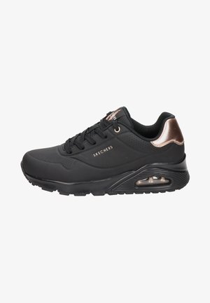 Schwarzer Sportschuh mit einer strukturierten synthetischen Oberseite, durchbrochenen Details, schnürbarem Design und einem roségoldenen Akzent an der Ferse. Transparente Luftsohle.