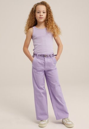 Lila tanktop met een ontspannen pasvorm, gecombineerd met wijde lila broek. De outfit bevat een patroonriem en neutrale sneakers.