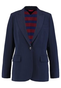 Tmavě modré sako na jeden knoflík, se dvěma předními kapsami a podšívkou s červenými a tmavě modrými pruhy. Střižené na míru a s hladkou texturou.