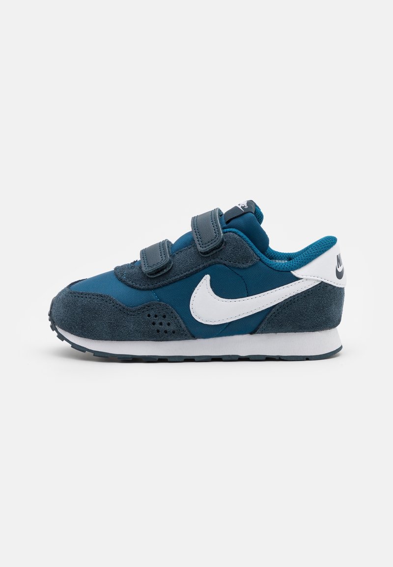 Dark blue children's sneakers with a combination of suede and fabric, featuring Velcro straps and a white Nike swoosh logo.