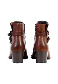 Brown leather ankle boots with a rounded toe, two side straps with buckles, and a stacked heel. Smooth texture, minimalist design.