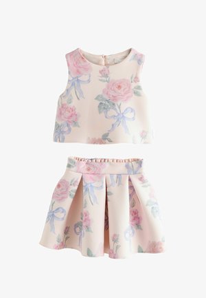 Bezruký crop top a plisovaná sukňa v bledoružovej farbe s veľkými pastelovými kvetinovými vzormi a motívmi svetlomodrých stužiek.