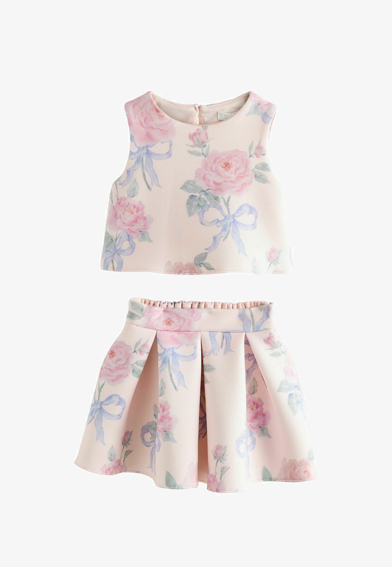 Ensemble top court sans manches et jupe plissée en rose pâle avec de grands imprimés floraux pastel et des motifs de rubans bleu clair.