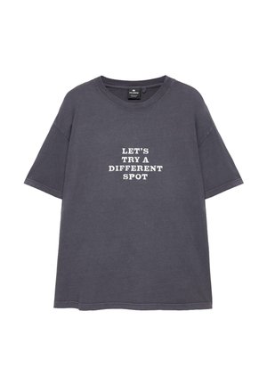 Tmavosivé bavlnené tričko s krátkym rukávom s bielym textom v strede: "LET'S TRY A DIFFERENT SPOT" veľkými písmenami.