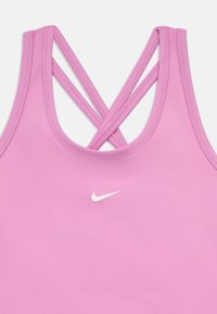 Ροζ αθλητικό tank top με σταυρωτές λεπτές τιράντες και μικρό λευκό λογότυπο Nike στο κέντρο κάτω από το ντεκολτέ.