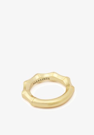 Anello color oro con design a bordo smerlato e incisione "ALLSAINTS" all'interno della fascia su sfondo bianco.