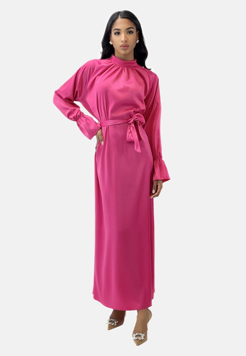 Lungo abito in satin rosa con collo alto, maniche lunghe e cintura in vita. Caratterizzato da dettagli arricciati sulle spalle e polsini svasati.