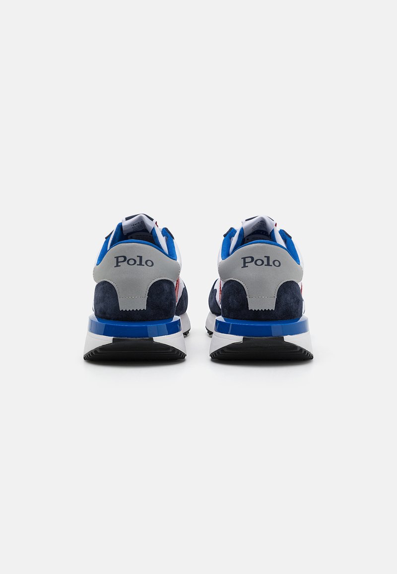 Zapatillas deportivas en azul y gris que combinan materiales de ante y malla, con un diseño de talón prominente y la marca "Polo" en la parte trasera.