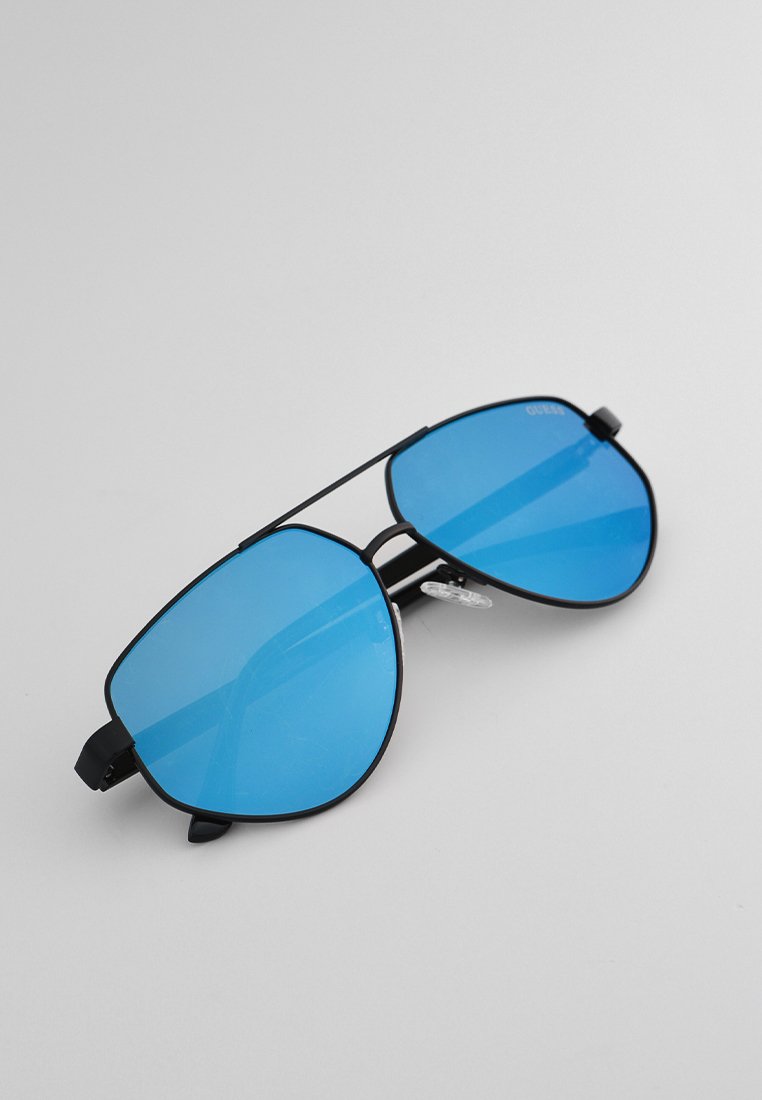 Occhiali da sole aviator con montatura in metallo black e lenti blu sfumate. Presentano un doppio ponte e naselli trasparenti per il comfort.