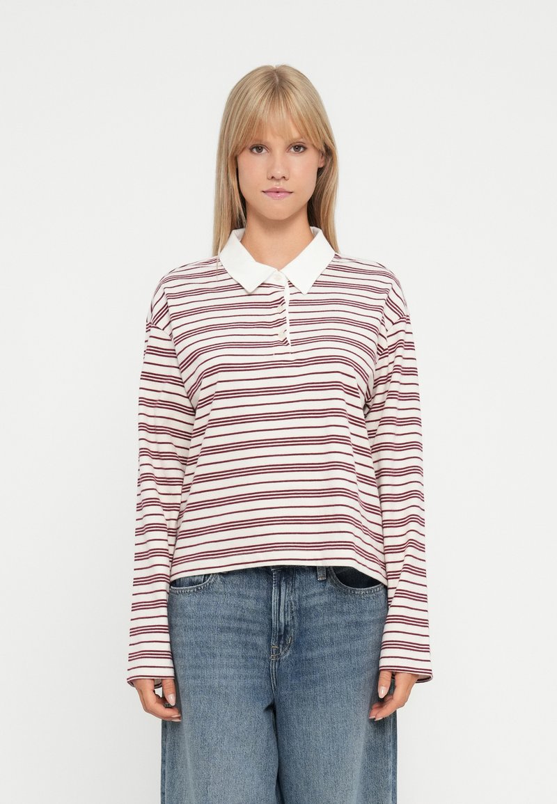 Polo à manches longues en écru avec des rayures horizontales bordeaux, doté d'un col classique et d'une coupe décontractée. Le tissu semble doux.