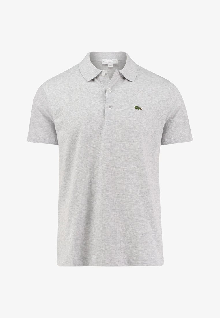 Polo gris à manches courtes, en coton texturé. Il présente un col classique et un petit logo crocodile vert sur la poitrine gauche.