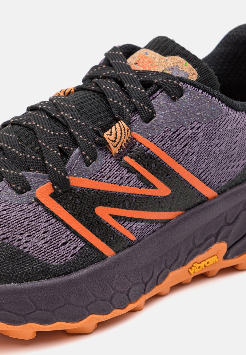 Lila und schwarze Sport-, die eine strukturierte Oberseite, orangefarbene Akzente und das Vibram-Logo auf der Sohle haben. Verfügt über Schnürsenkel und ein gepolstertes Design.