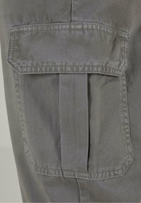 Szara bawełniana tkanina o diagonalnym splocie, z dużą klapkową kieszenią i plisą, przeszyta dopasowanym niciem dla trwałości.