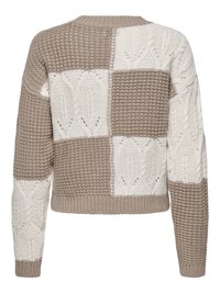 Pull patchwork tricoté beige et blanc avec motifs alternés texturés et torsadés, manches longues, poignets et ourlet côtelés.