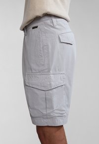Pantalones cortos de carga gris claro, hechos de un tejido ligero, con bolsillos laterales y un logo bordado texturizado en el bolsillo trasero.