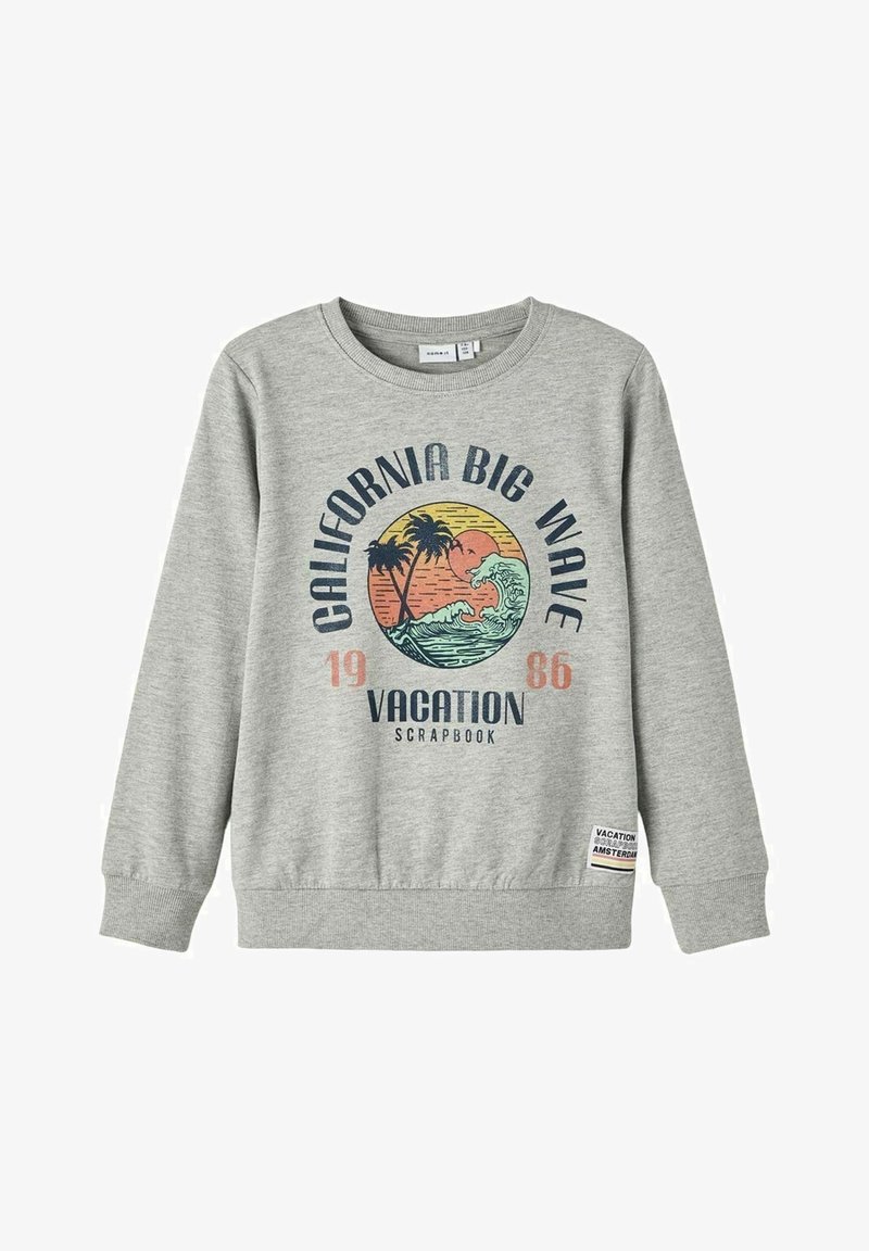 Sweat-shirt gris clair avec motif palmier et vague, texte "California Big Wave 1986 Vacation Scrapbook," et petite étiquette au bas de l'ourlet.