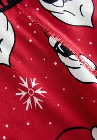 Red fabric featuring a winter-themed pattern with white snowflakes and cartoon faces; includes a visible zipper and smooth texture.