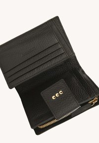 Portefeuille en cuir noir texturé ouvert pour montrer des emplacements pour cartes, un rabat à bouton-pression avec trois clous dorés, et un compartiment zippé doré.