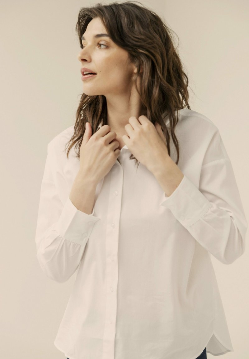 Witte button-up overhemd van lichtgewicht stof, met lange mouwen, een klassieke kraag en een relaxte pasvorm met een afgeronde zoom.
