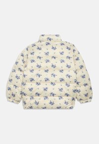 Puffjakke i krem med blåblomstrete mønster. Har en stående krage og innsamlede ermer. Kviltet design med oppblåste seksjoner.