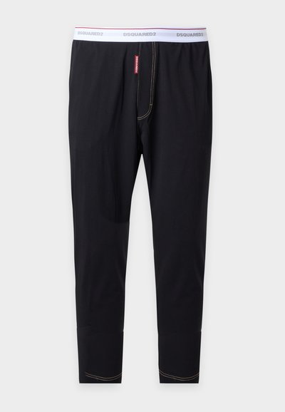 Pantalon long noir moulant avec taille élastique blanche marquée "DSQUARED2" et détails de couture visibles.