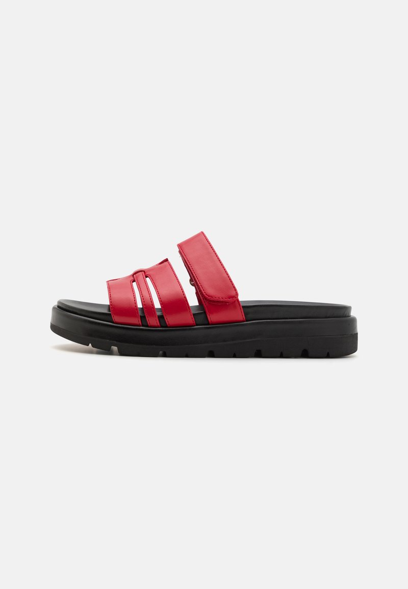 Red synthetic slide sandals with three horizontal straps and a black rubber sole. Features a flat design and reinforced edges for durability.