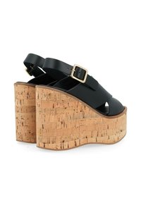 Sandali neri con piattaforma e tacco in sughero, dotati di cinturini regolabili e fibbie in oro. La parte superiore presenta una texture liscia e un design con intagli.