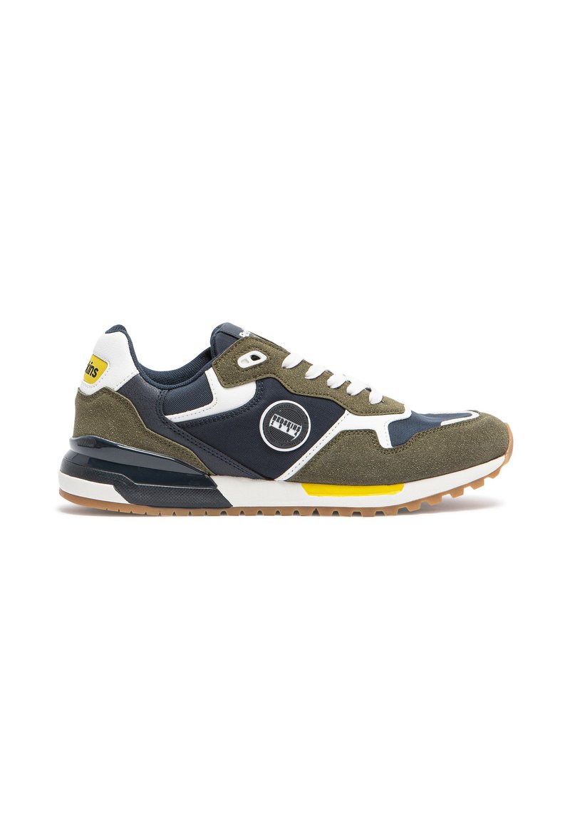 Des chaussures de sport vertes et marine en matériau suédé et en mesh, avec un logo blanc, une accentuation jaune et une semelle en caoutchouc texturée.