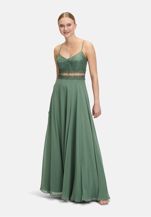 Langes grünes Kleid mit Spaghetti-Trägern, das einen Spitzen-Bodice und einen fließenden Rock aufweist. Die glatte Stofftextur verstärkt das elegante Design.