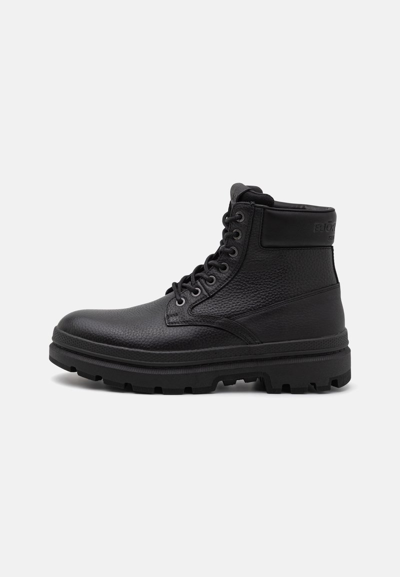 Stivaletto in pelle nera con finitura texturizzata, punta rotonda, sei occhielli e suola robusta. Presenta un collo imbottito e un logo discreto.