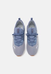 Scarpe da ginnastica azzurro chiaro realizzate in rete traspirante, con punta arrotondata, finitura testurizzata e lacci elastici, con un logo bianco sul lato.
