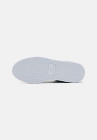 Sola de borracha branca com padrão pesqueiro e logótipo em relevo. Textura suave, forma arredondada, design minimalista, adequado para uso casual.