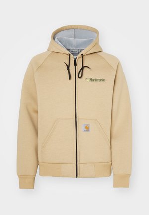 Hoodie zipé beige avec capuche à cordon, poches avant, fermeture éclair noire et détail de logo. Tissu doux avec poignets et ourlet côtelés.