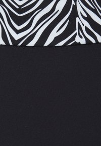 Schwarzer Badeanzug mit einem Oberteil im Zebramuster in Schwarz und Weiß. Glatte Textur, elastisches Material und nahtloses Design für Komfort.