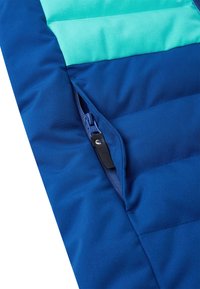 Marineblaue gepolsterte Jacke mit türkisfarbenem oberen Abschnitt; verfügt über einen blauen Reißverschluss und eine Seitentasche. Weicher, strukturierter Stoff.