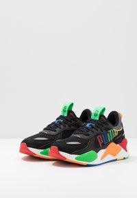 Black athletic shoes with mesh upper, multicolor accents in red, green, blue, and yellow, rounded toe, and cushioned sole.